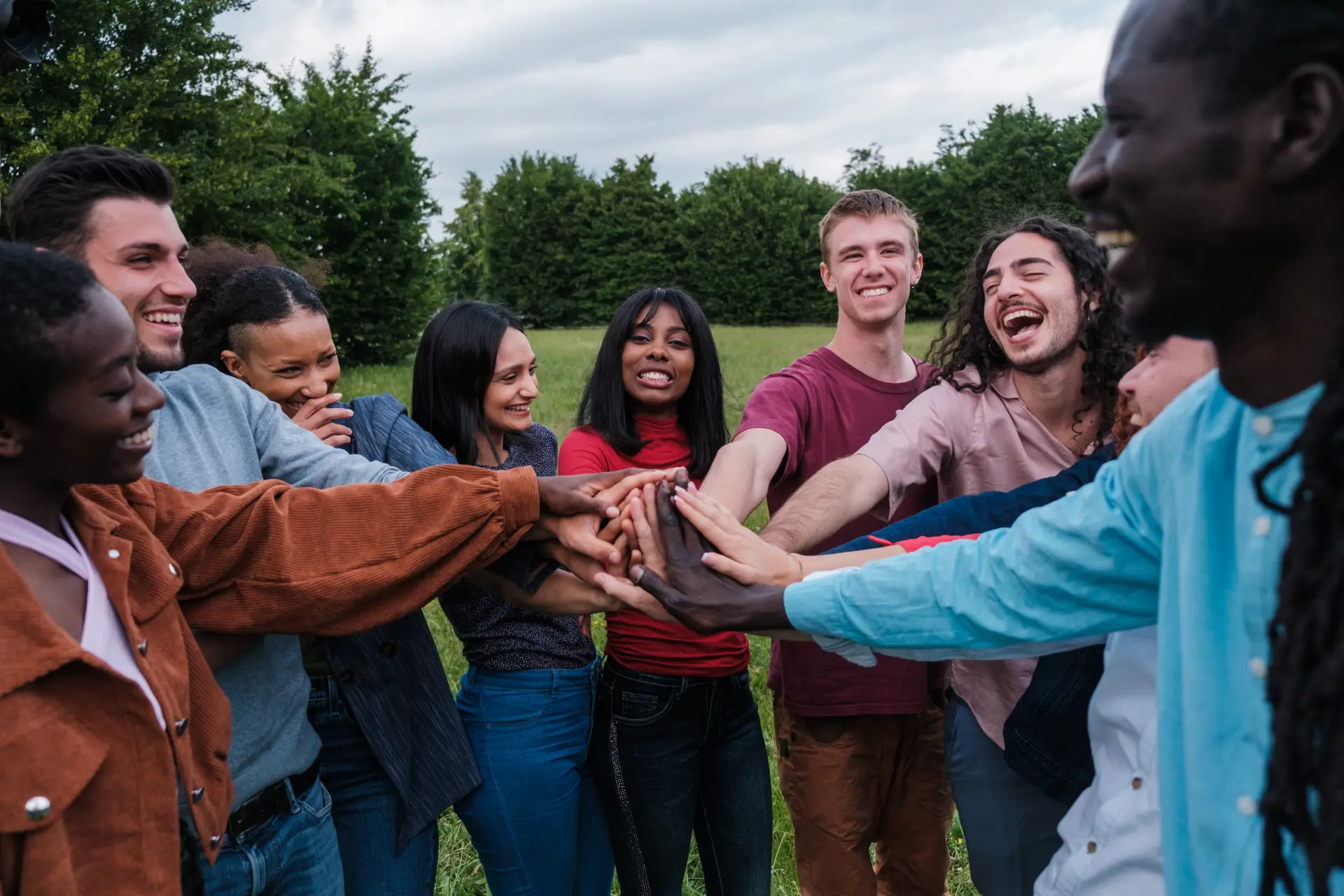 Group of friends with different cultures gathered in a park having a fun time together